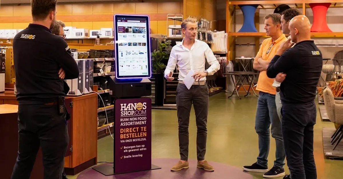 HANOS SHOP Bestellkiosk in einer Filiale, entworfen und geliefert von Prestop, mit kundenspezifischer Plakatplatte und integrierter Software.