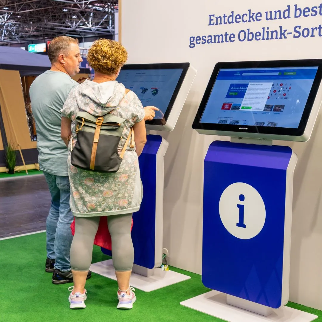 Mann und Frau finden mithilfe eines Kiosks den Weg.